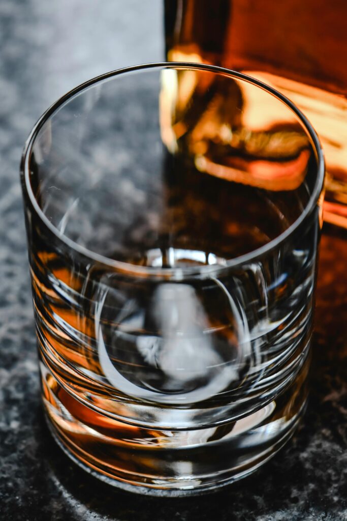 Close-up shot of an empty elegant whiskey glass on a granite surface.